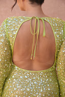 a back of a woman wearing a green dress